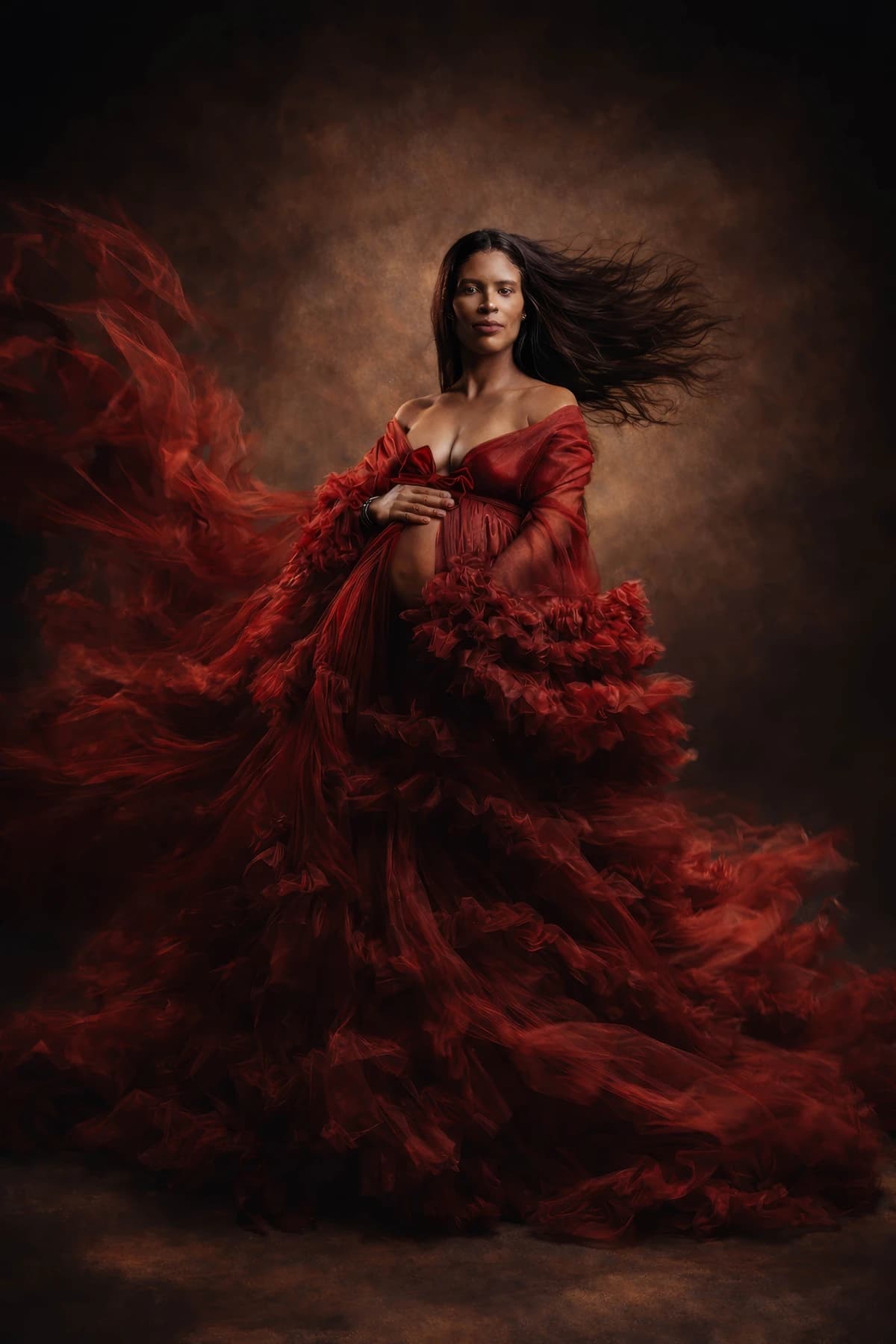 Maternity portrait in a flowing red ruffled gown