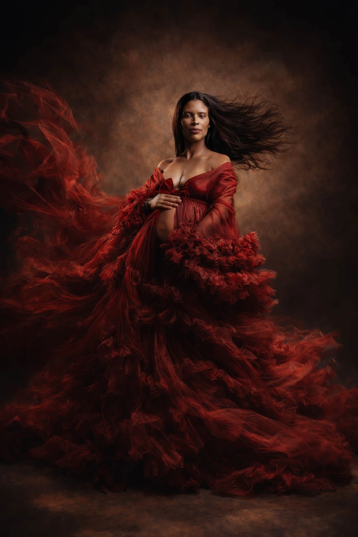 Maternity portrait in a flowing red ruffled gown